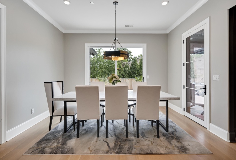 Dining area featuring light wood-finish flooring and a contemporary chandelier