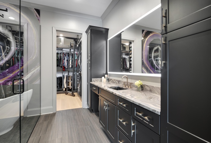 Custom vanity with integrated sink, stone countertop, and custom cabinetry