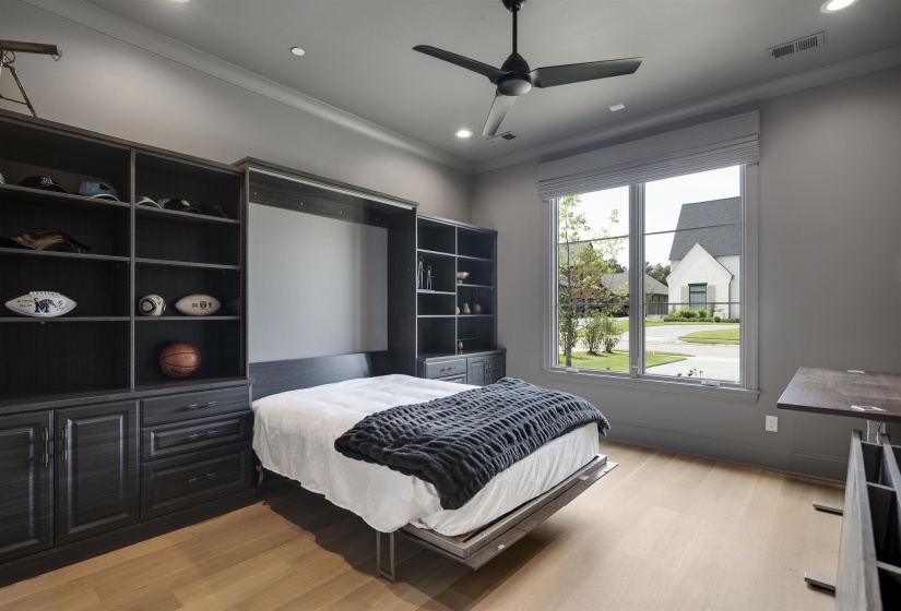 Space-saving Murphy bed integrated into custom dark wood cabinetry