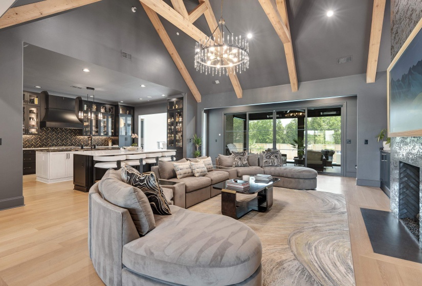 Open-concept living space featuring a vaulted ceiling with exposed wood beams