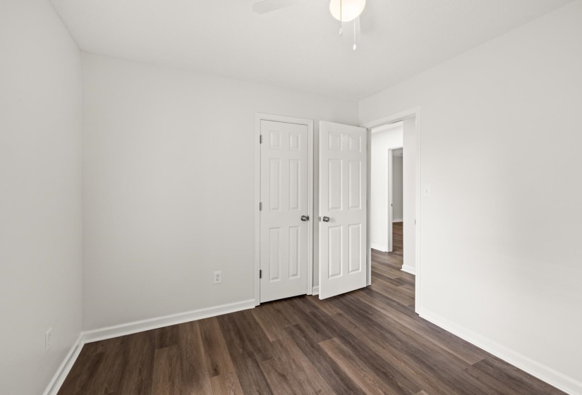 Room featuring wood-finish flooring, white baseboards, and neutral wall tones