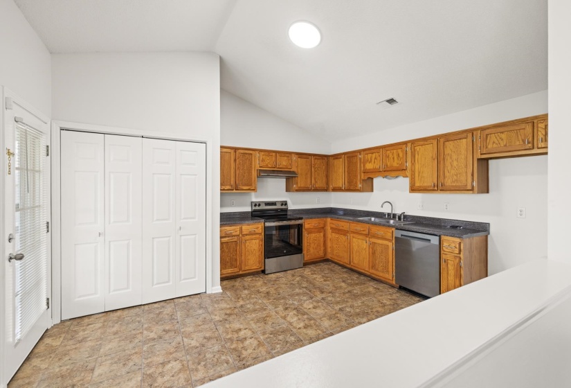 Kitchen featuring wood-finish cabinetry, stainless steel appliances, and a skylight