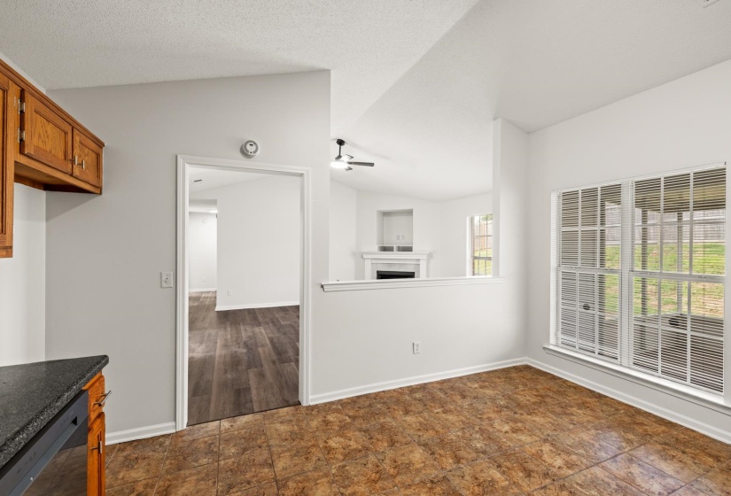 Kitchen area with stone-look flooring, wood cabinetry, and a dark countertop