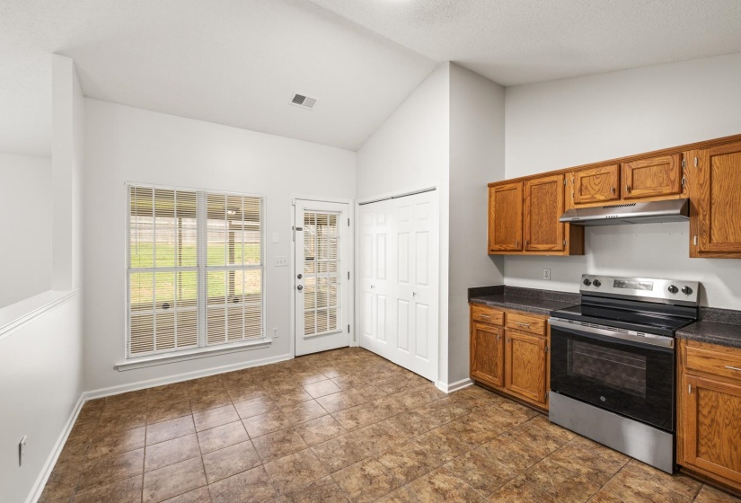 Kitchen featuring wood cabinetry, dark countertops, and stainless steel appliances