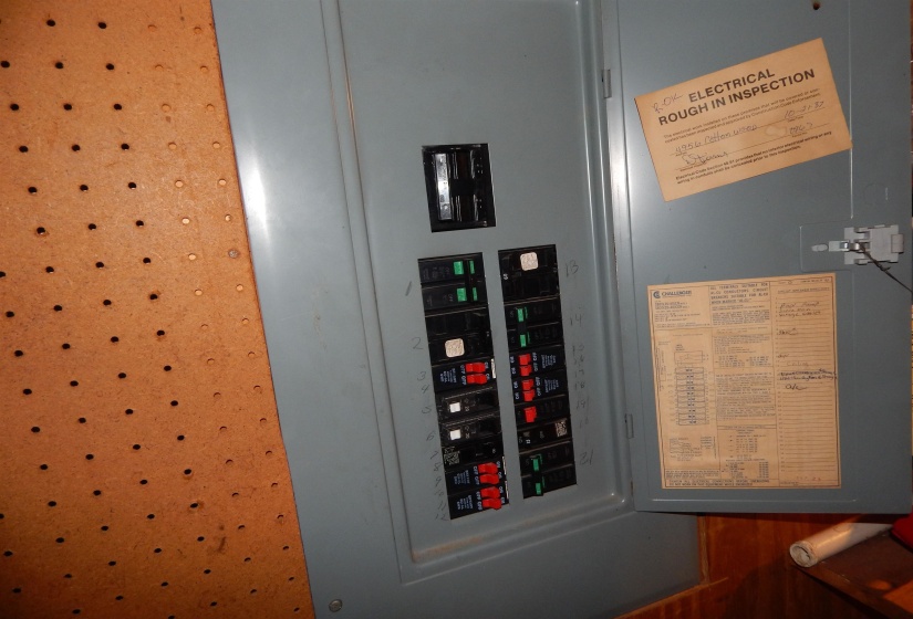 Electrical panel featuring a gray metal enclosure and a variety of circuit breakers
