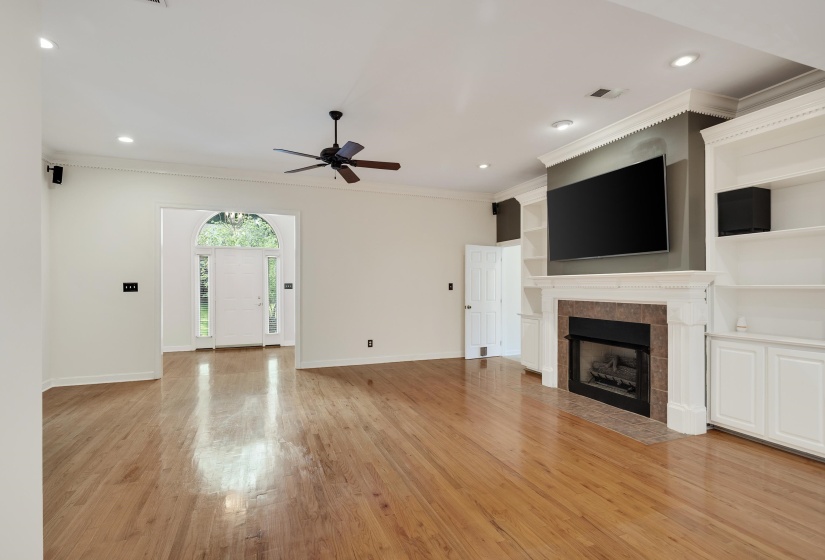Spacious living area featuring wood-finish flooring, a ceiling fan, and recessed lighting