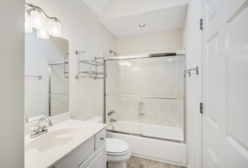 Full bathroom featuring a white vanity with integrated sink, chrome faucet, and overhead lighting