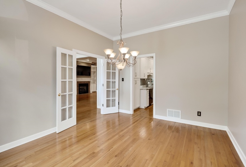 Room featuring hardwood flooring and a chandelier light fixture