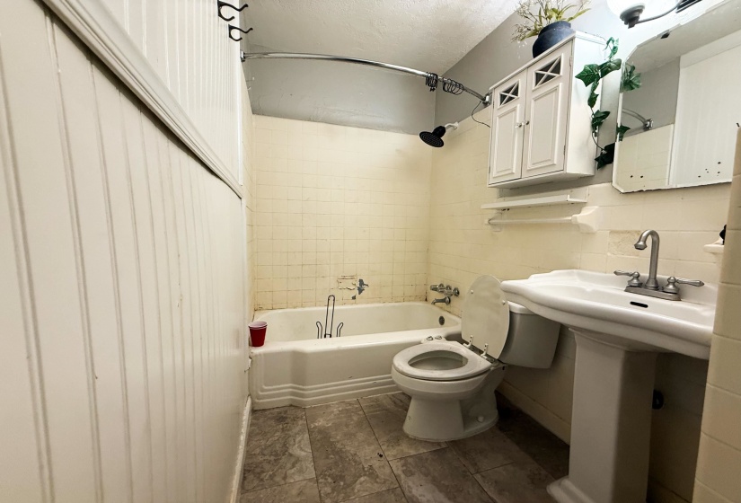 Bathroom featuring a textured ceiling and tub / shower combination