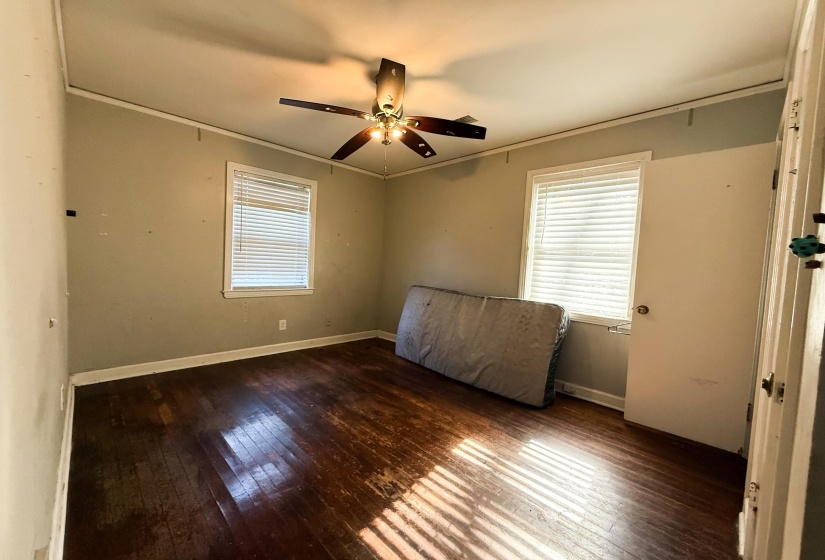 Unfurnished bedroom with dark wood-style floors and a ceiling fan
