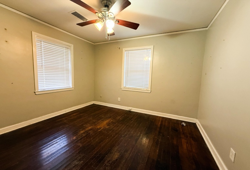 Spare room with dark wood-style flooring, ceiling fan, and ornamental molding