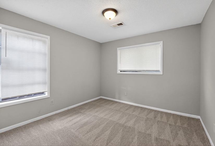 Unfurnished room with light colored carpet and a textured ceiling