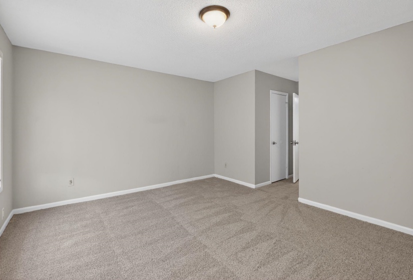Spare room featuring light carpet and a textured ceiling