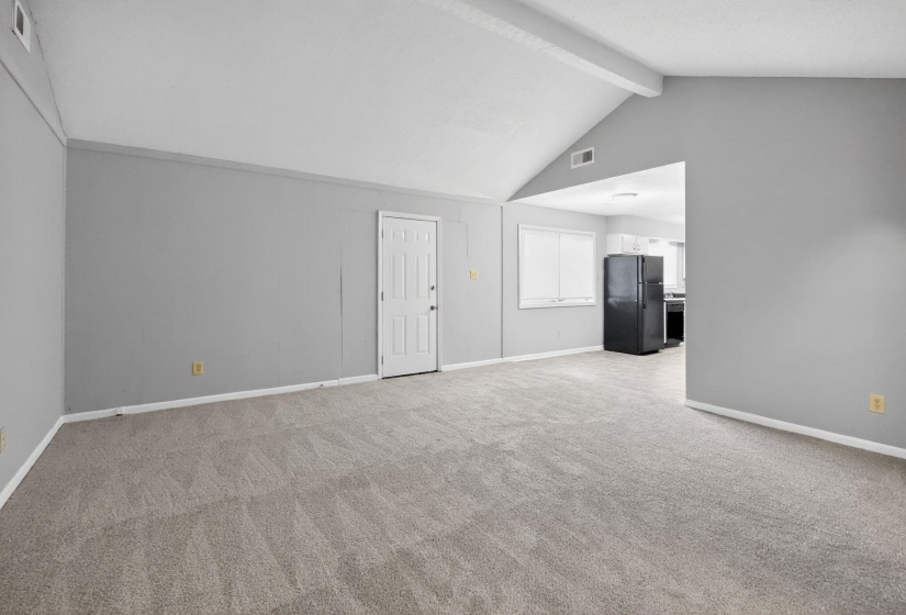 Unfurnished living room with baseboards and light colored carpet