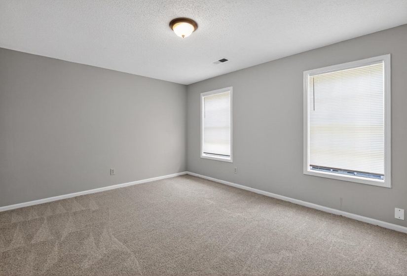 Unfurnished room featuring light carpet and a textured ceiling