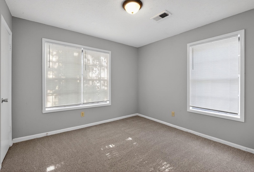 Spare room with baseboards and dark colored carpet