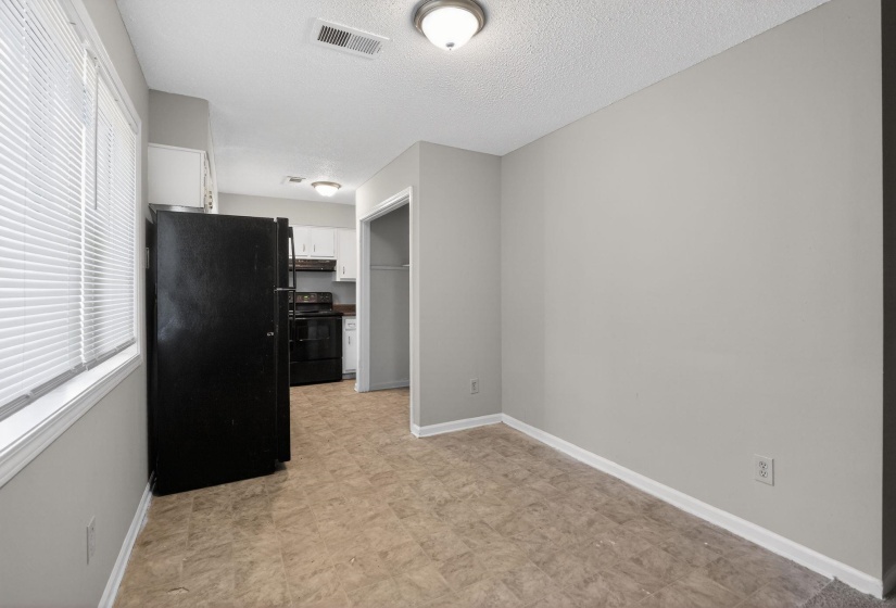Kitchen featuring black appliances, white cabinets, and a textured ceiling