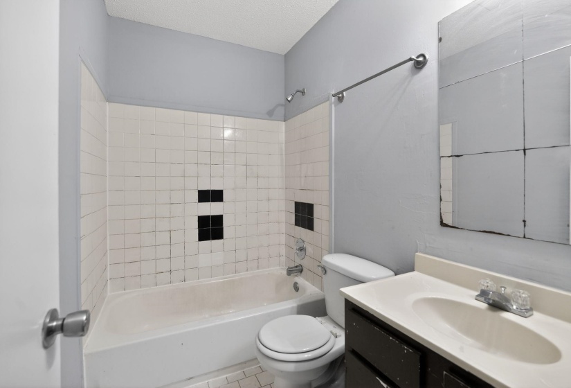 Bathroom with vanity, shower / washtub combination, and a textured ceiling