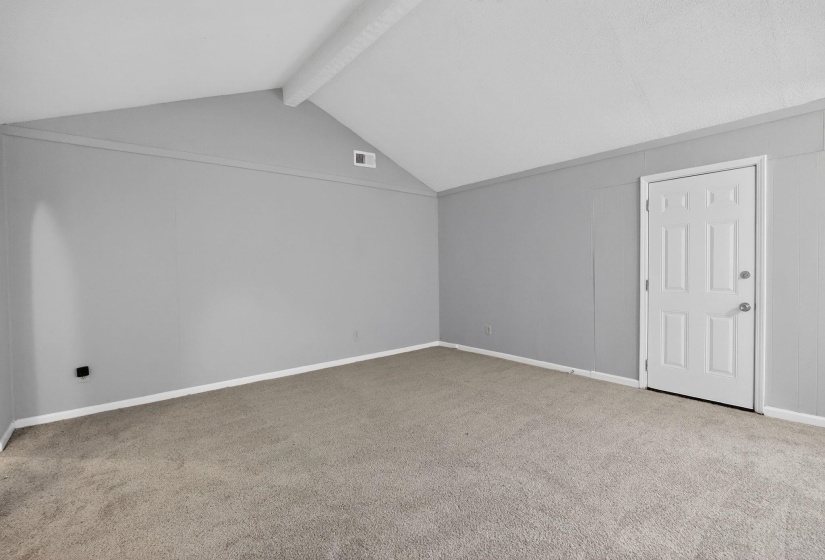 Bonus room with beamed ceiling and carpet flooring