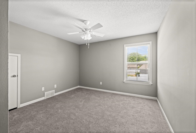Carpeted room featuring a ceiling fan, white trim, and a window with blinds