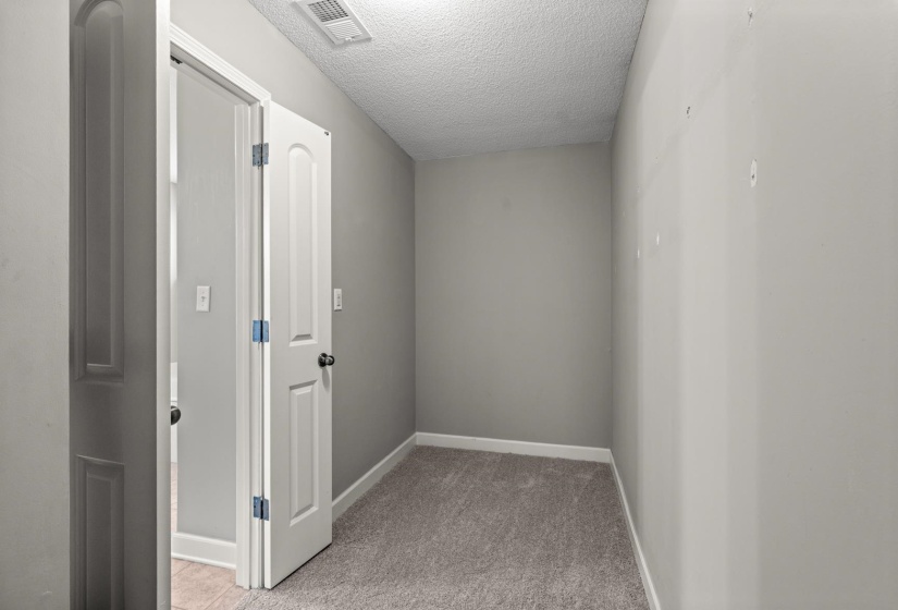 Interior room featuring plush gray carpeting, neutral gray wall paint, and white trim