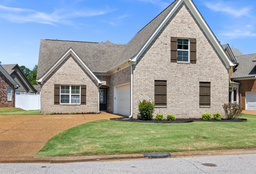 Brick exterior residence with a shingled roof and an attached garage