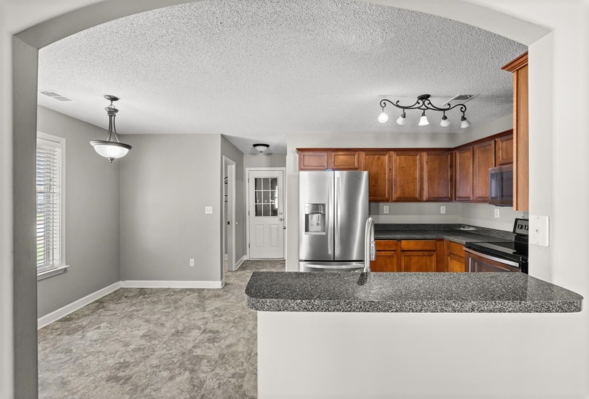 Open-concept kitchen and dining area featuring a breakfast bar with a speckled countertop