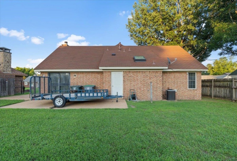 Expansive backyard featuring a brick exterior and a privacy fence
