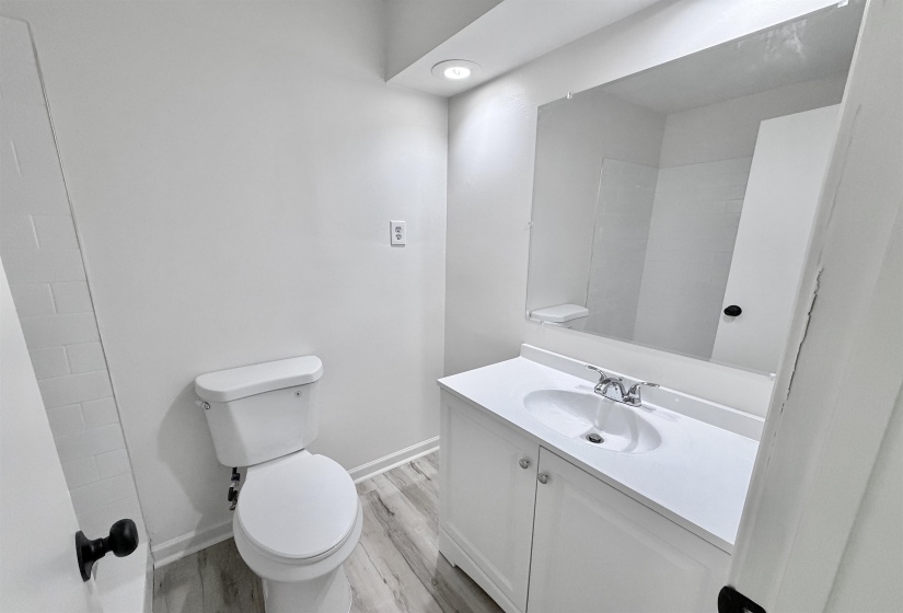 Bathroom featuring a white vanity with an integrated sink, polished chrome faucet, and a large wall-mounted mirror