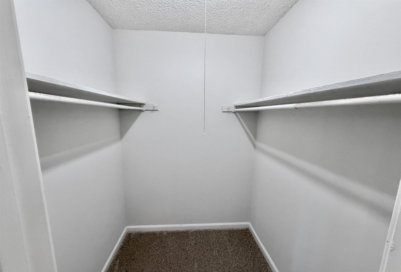Walk-in closet with shelving and hanging rods