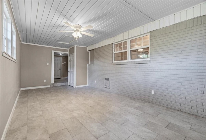 Spacious room featuring light gray tile flooring and a white paneled ceiling