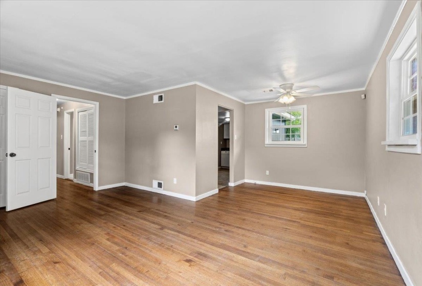 Spacious room featuring wood-finish flooring, neutral-toned walls, and white trim
