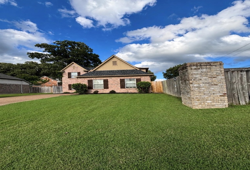 Brick facade residence featuring dark shutters, a contrasting gable, and a gabled roofline