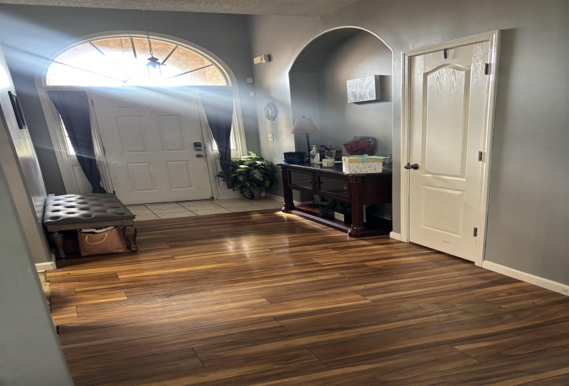 Entryway featuring wood-finish flooring, an arched doorway, and an arched transom window above the main entry door