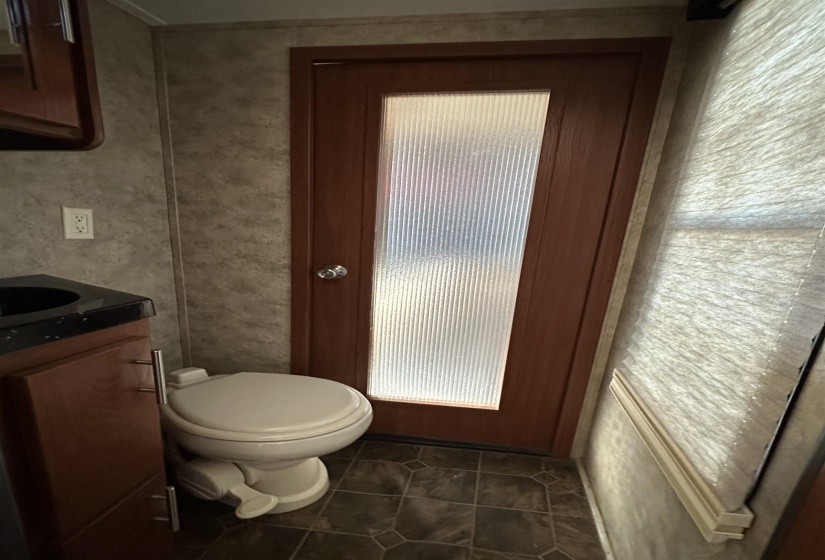 Bathroom with toilet, tile patterned flooring, and vanity