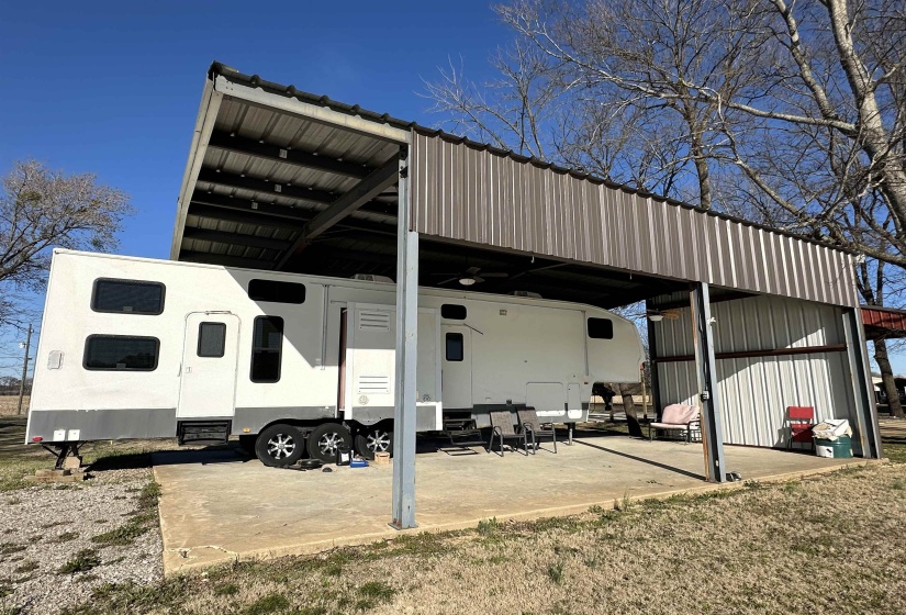 View of parking / parking lot featuring a detached carport and entry steps