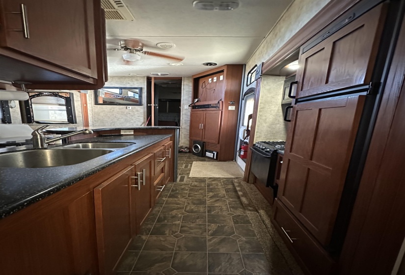 Kitchen featuring dark stone counters, black range with gas cooktop, and a sink