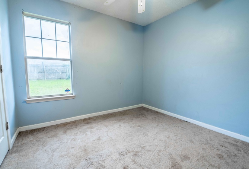 Bright interior space featuring a multi-pane window, light blue walls, and neutral carpeting