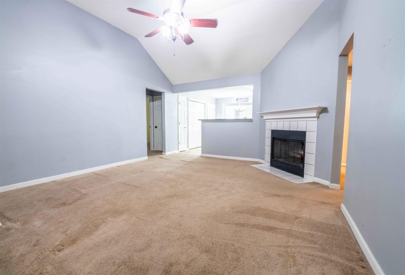 Living area featuring a vaulted ceiling and a ceiling fan