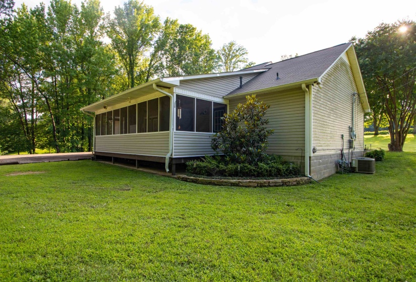 Exterior featuring light-colored siding, a screened porch, and a dark shingle roof
