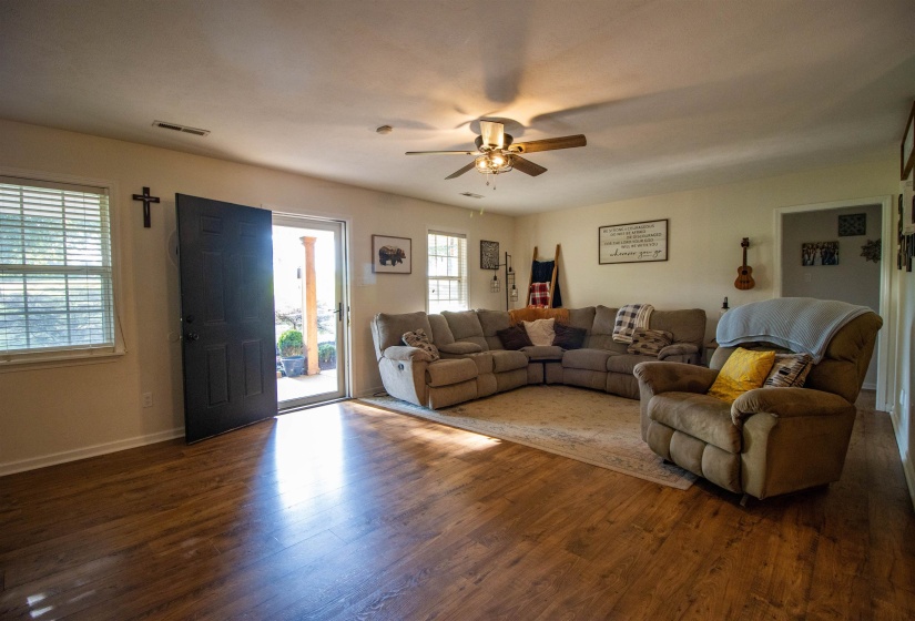 Spacious Great Room featuring wood-finish flooring, white baseboards, and a ceiling fan