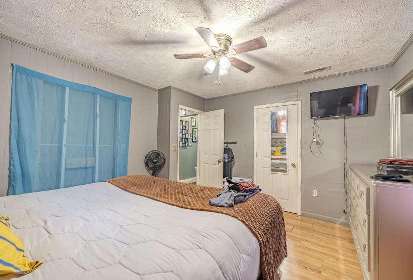 Interior space featuring wood-finish flooring, a ceiling fan with light fixture, and paneling on the walls