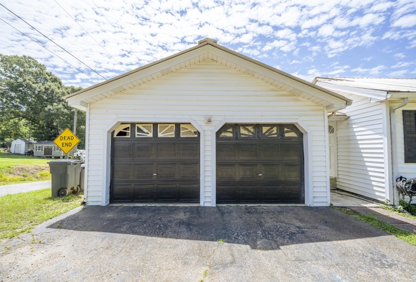 Two-car garage featuring dark-colored doors with decorative window inserts