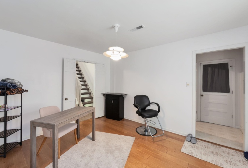 Bright room with wood-finish flooring, white walls, and a contemporary ceiling fixture