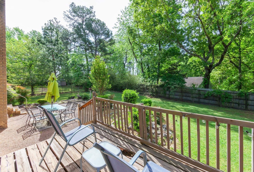 Expansive wood deck with a natural wood railing overlooking a manicured lawn