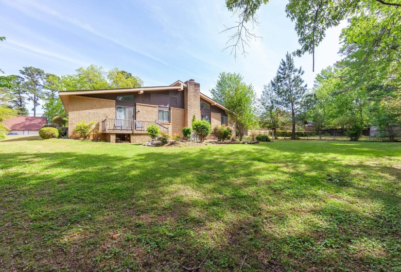 Expansive backyard featuring a lush lawn and mature trees