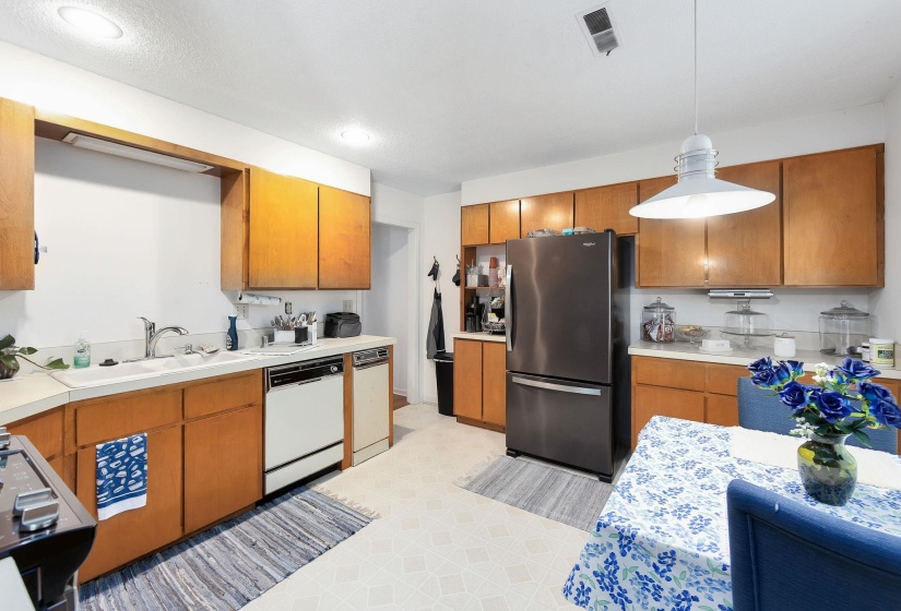 Kitchen featuring wood-finish cabinetry, light countertops, and recessed ceiling lighting