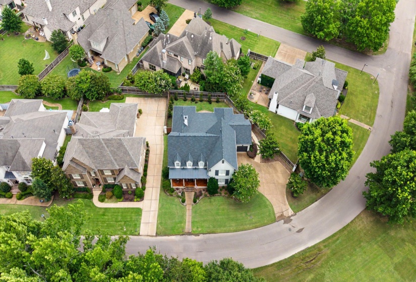 Traditional-style residence featuring a dark-hued roof, a light-colored exterior, and an inviting front porch with columns