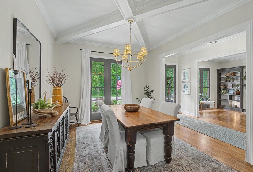 Dining area featuring a coffered ceiling with a chandelier, hardwood flooring, and French doors
