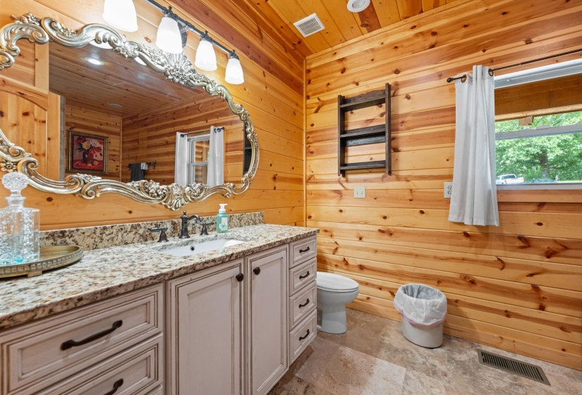 Bathroom featuring natural wood plank walls and a vanity with a light-colored countertop